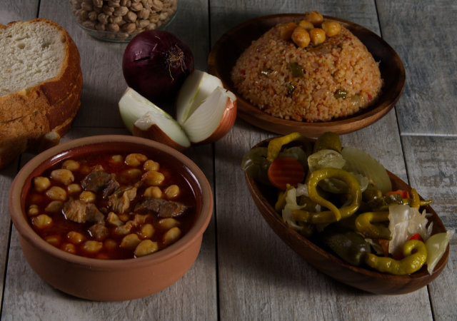 Güveçte Etli Nohut, Ahşap Tabakta Bulgur Pilavı ve Karışık Turşu Yatay Format 1